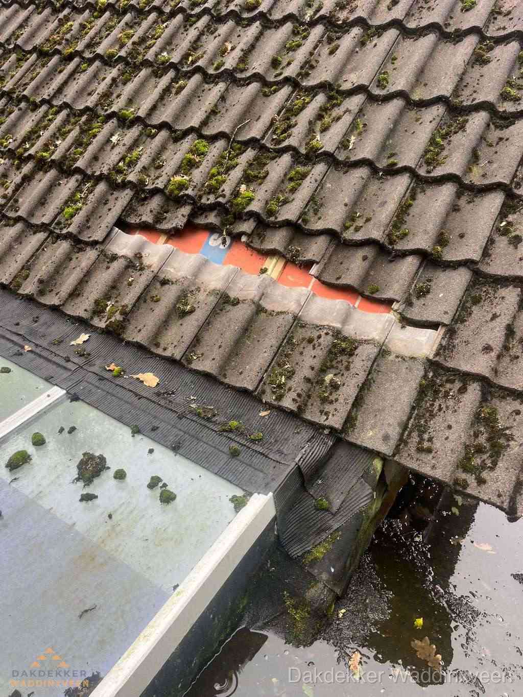 Beschadigd pannendak met ontbrekende dakpannen voor reparatie in Waddinxveen