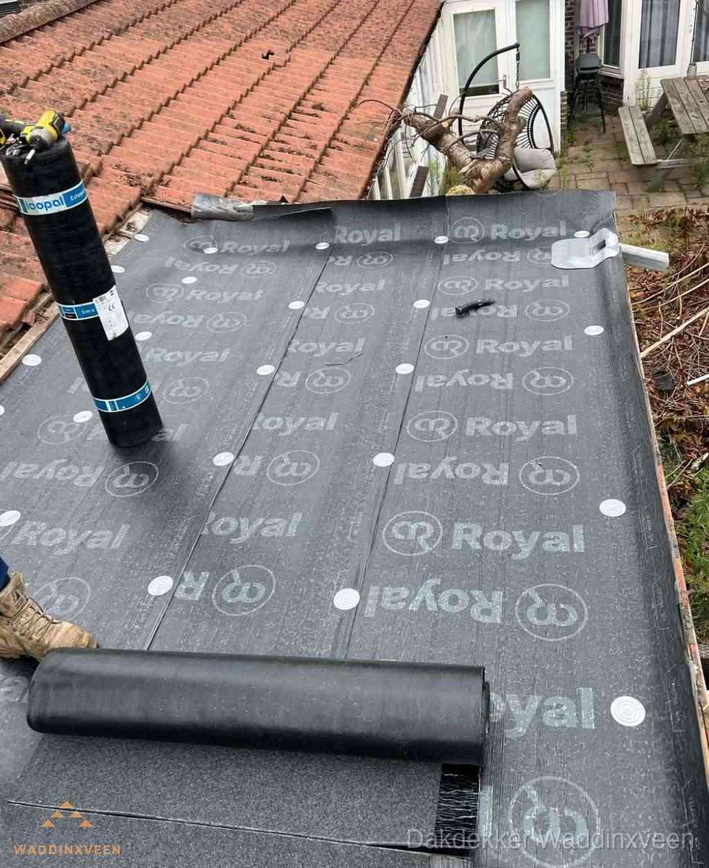 Plat dak met nieuwe bitumen dakbedekking en brandgereedschap in Waddinxveen