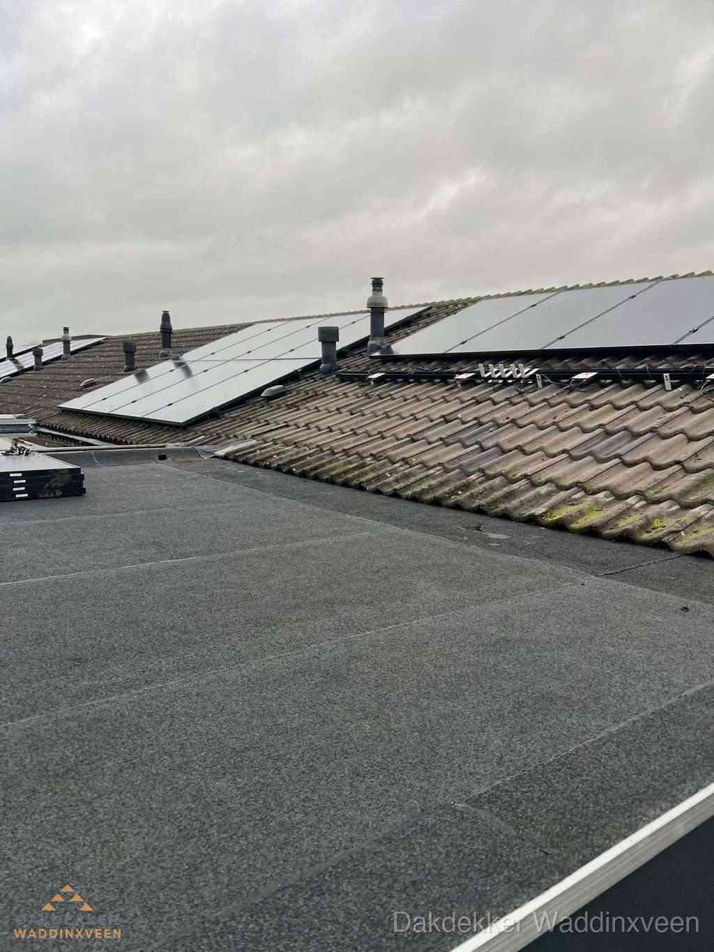 Plat dak inspectie met bitumen bedekking naast schuin pannendak in Waddinxveen