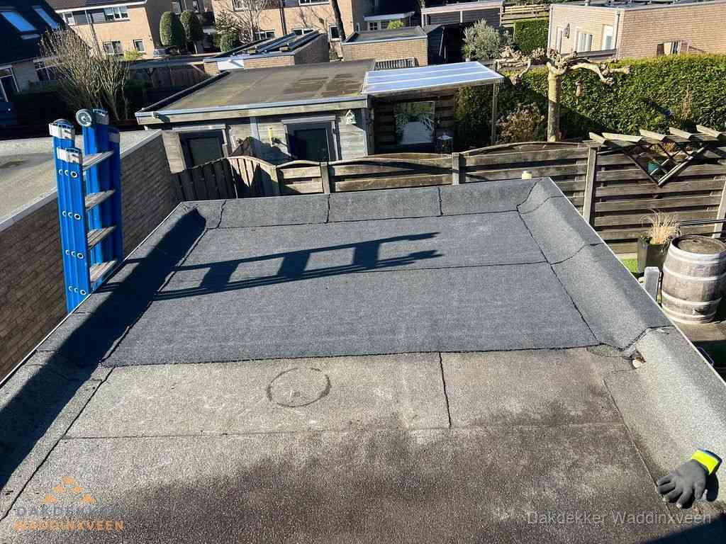 Dakdekker legt onderlaag op plat dak met houten constructie in Waddinxveen