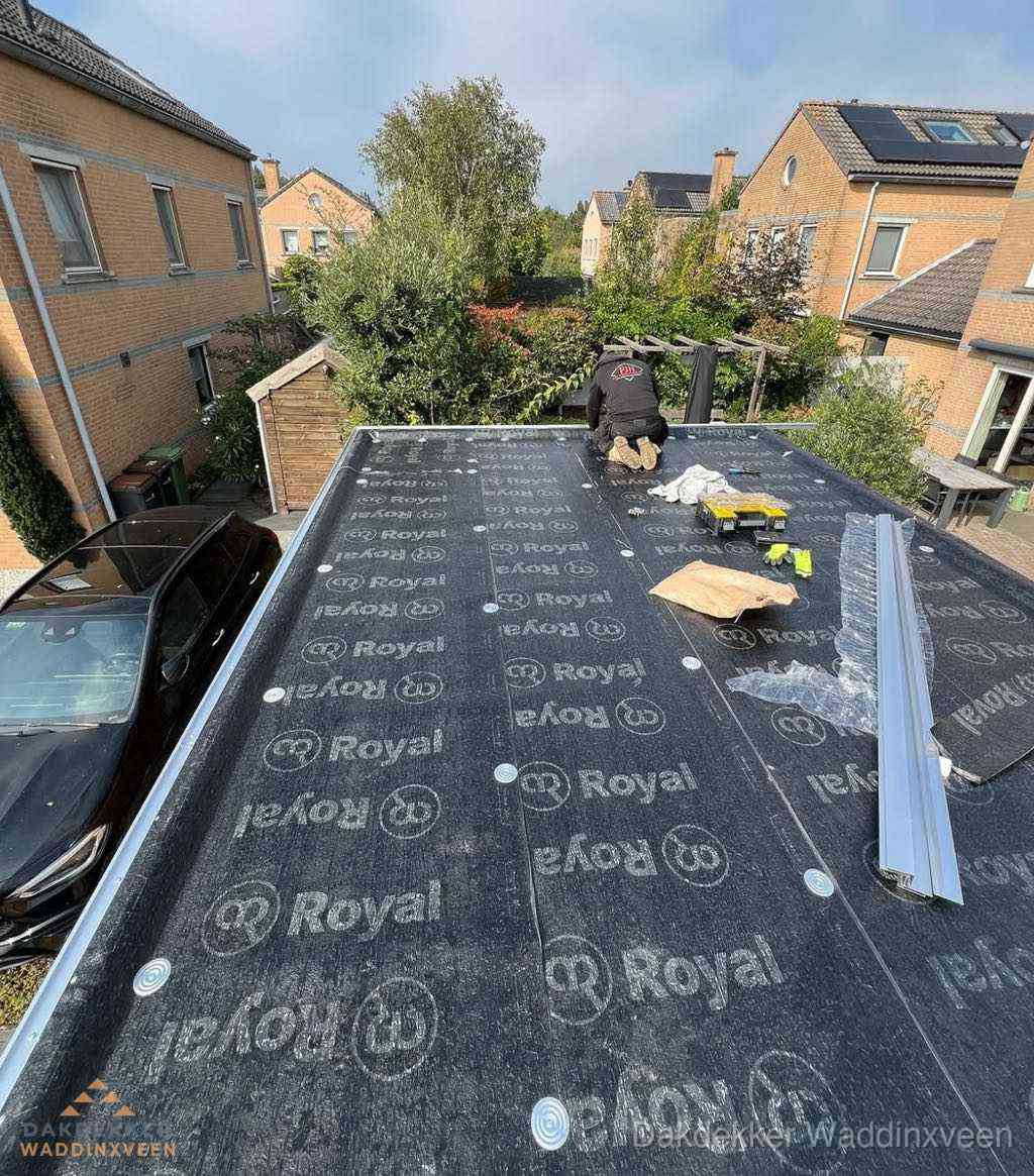Dakdekker aan het werk op plat dak renovatie in Waddinxveen