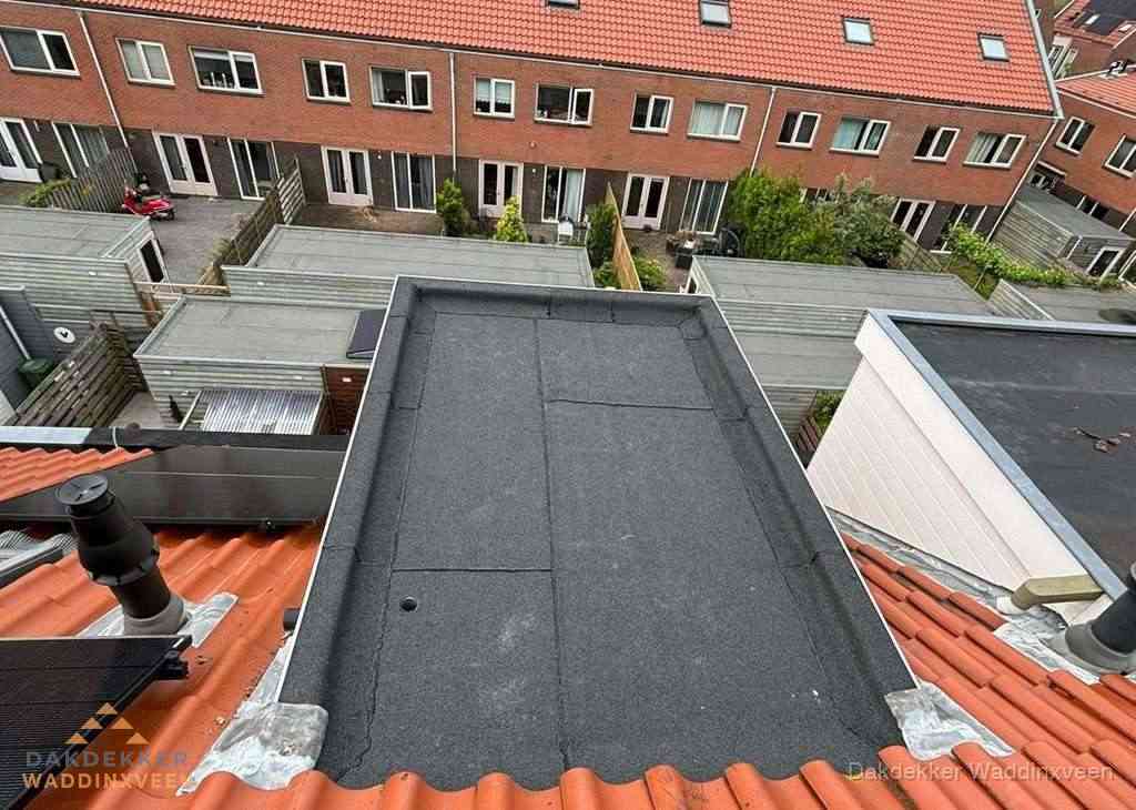 Plat dak met bitumen bedekking naast dakkapel in Waddinxveen