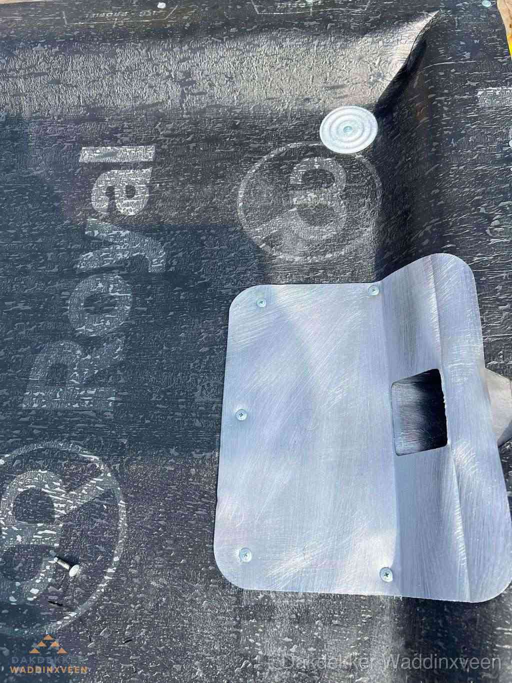 Dakdoorvoer met metalen afvoerplaat op bitumen dak in Waddinxveen