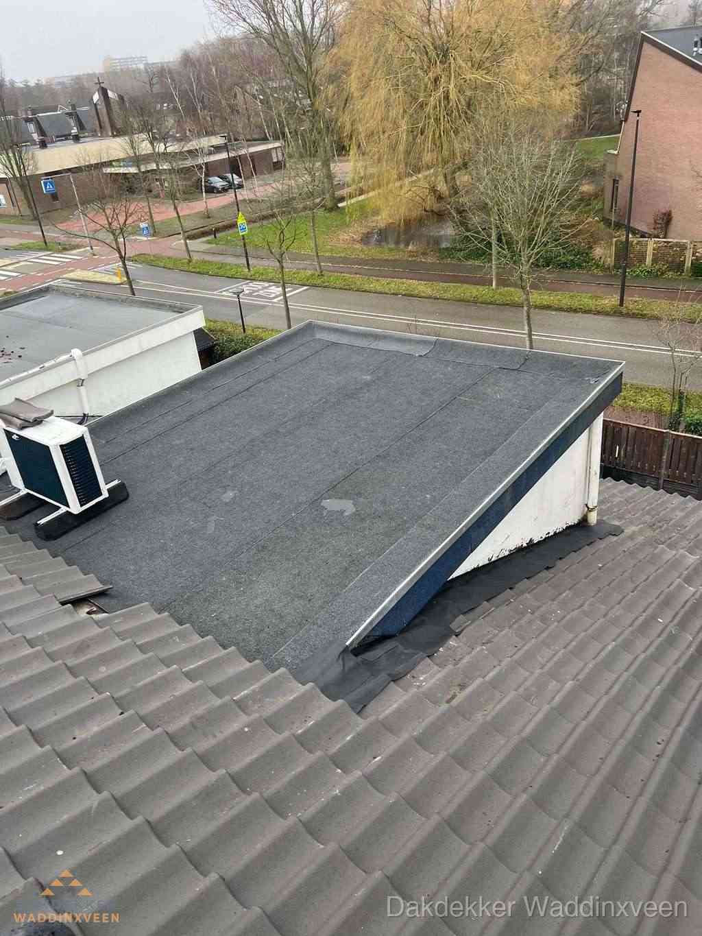 Plat dak met bitumen dakbedekking naast schuin pannendak in Waddinxveen