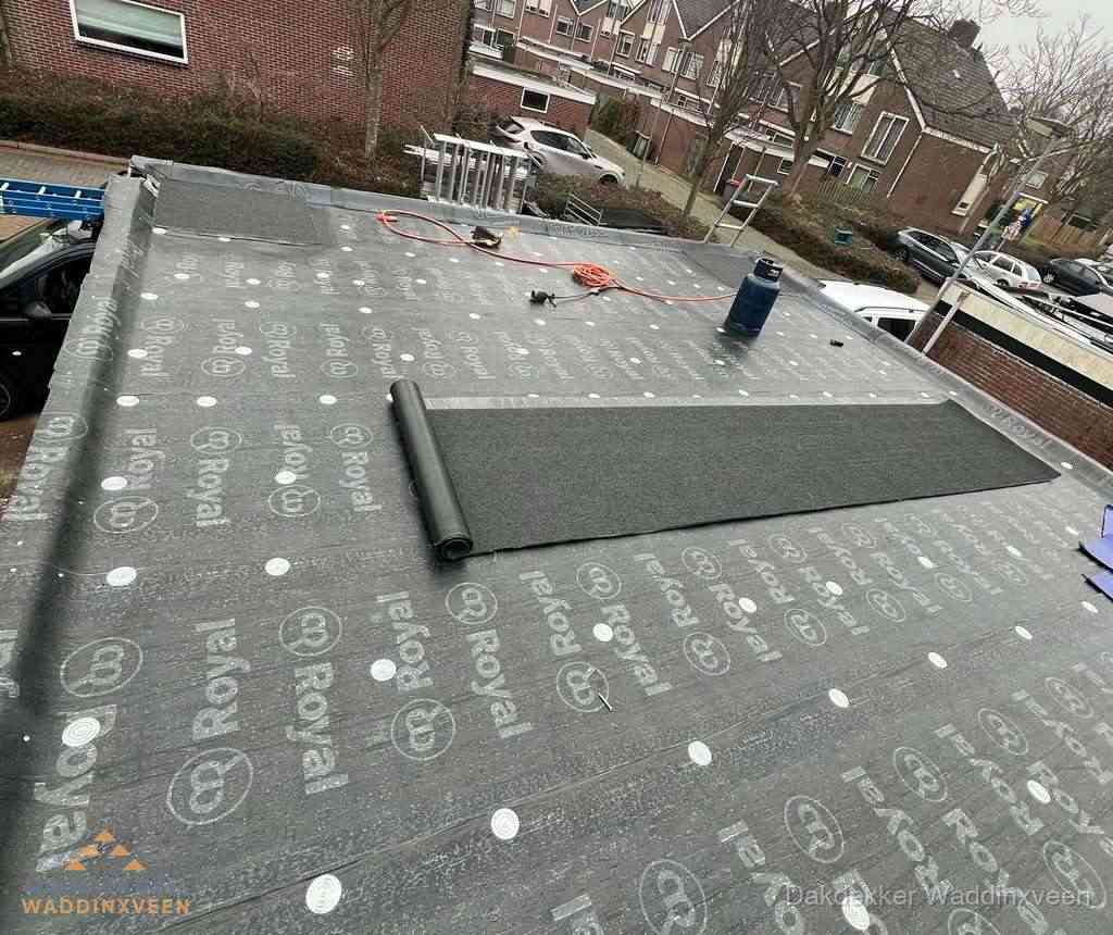 Dakdekker aan het werk met gasbrander op plat bitumen dak in Waddinxveen
