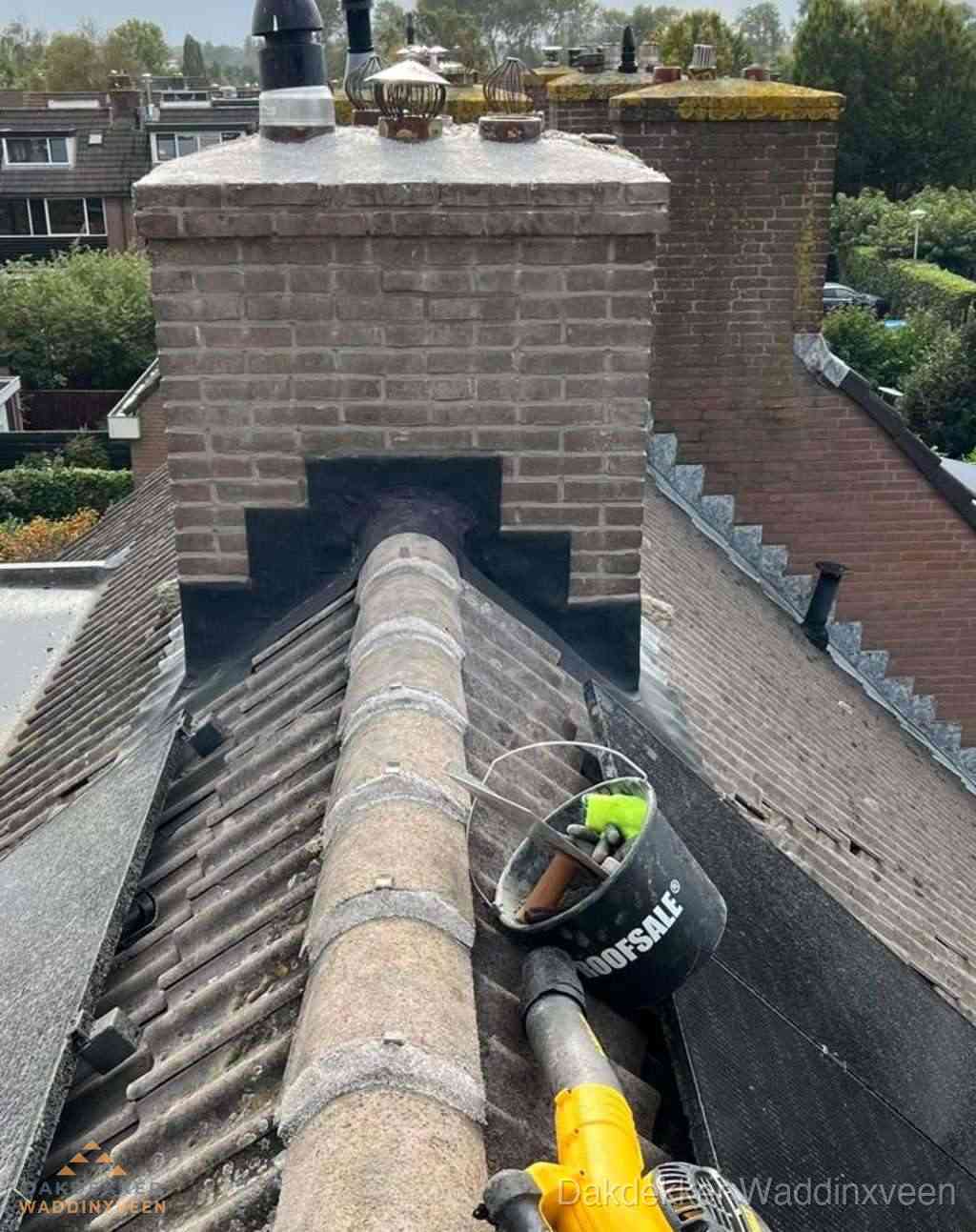 Dakdekker repareert bitumen dakleer bij dakdoorvoer in Waddinxveen